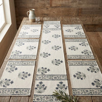 Set of floral-patterned table runners on a wooden table with a rustic background.