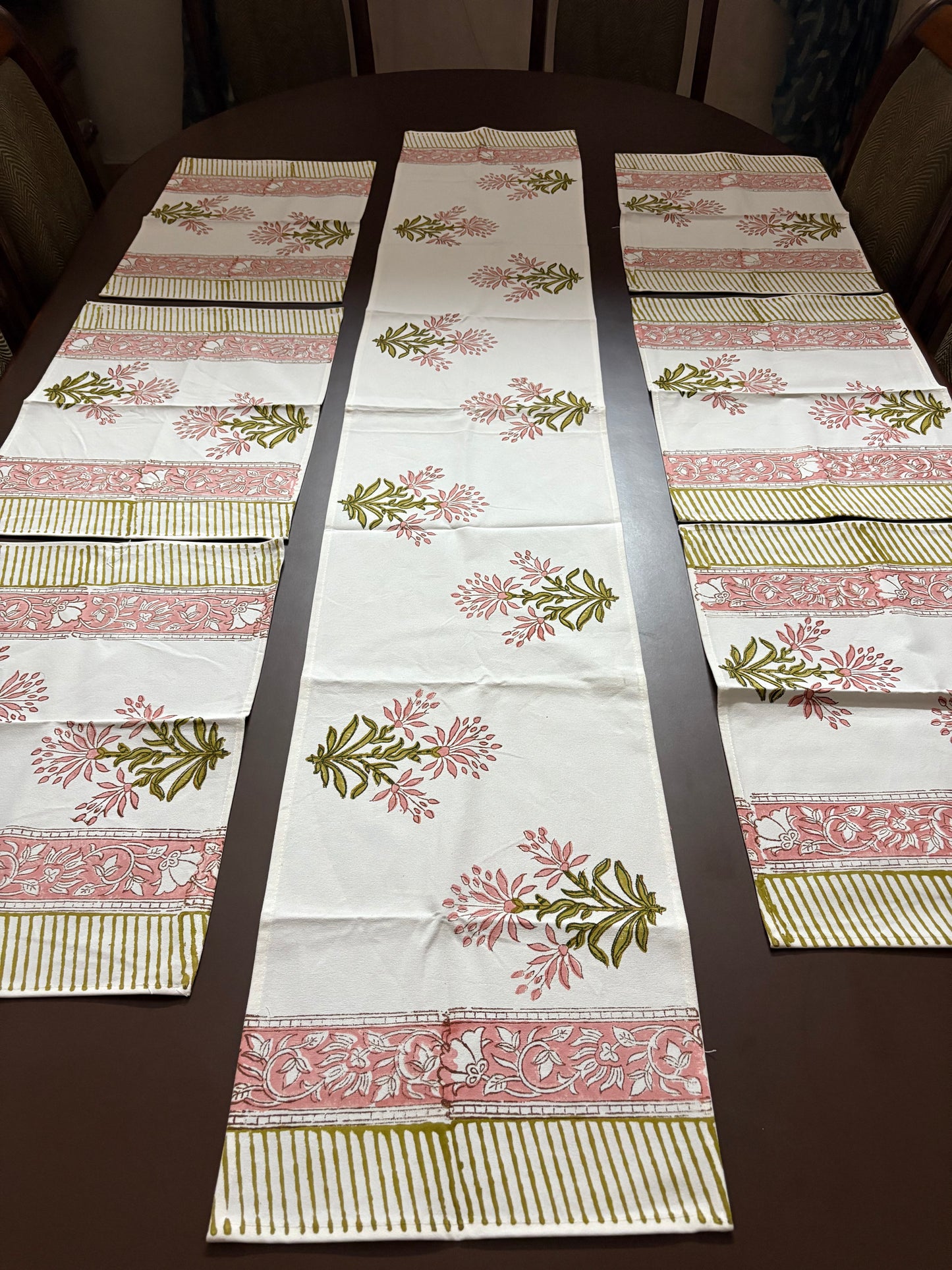 Decorative table runner with floral and striped patterns on a wooden table.100% authentic handblock printed fabrics by savai home. Indian textiles