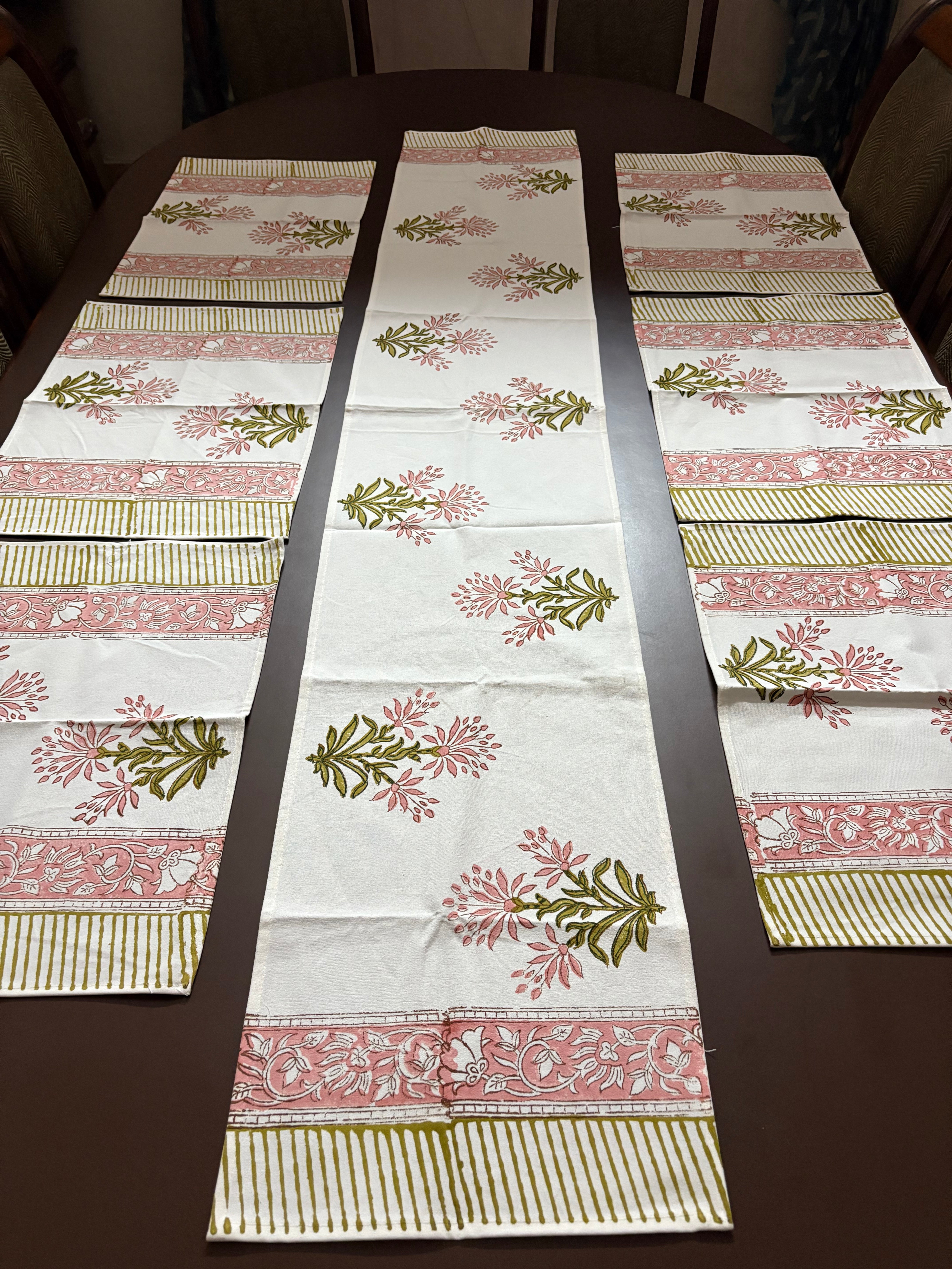 Decorative table runner with floral and striped patterns on a wooden table.100% authentic handblock printed fabrics by savai home. Indian textiles