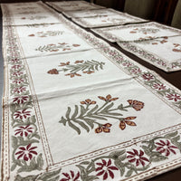Decorative tablecloth with floral patterns on a wooden table.
