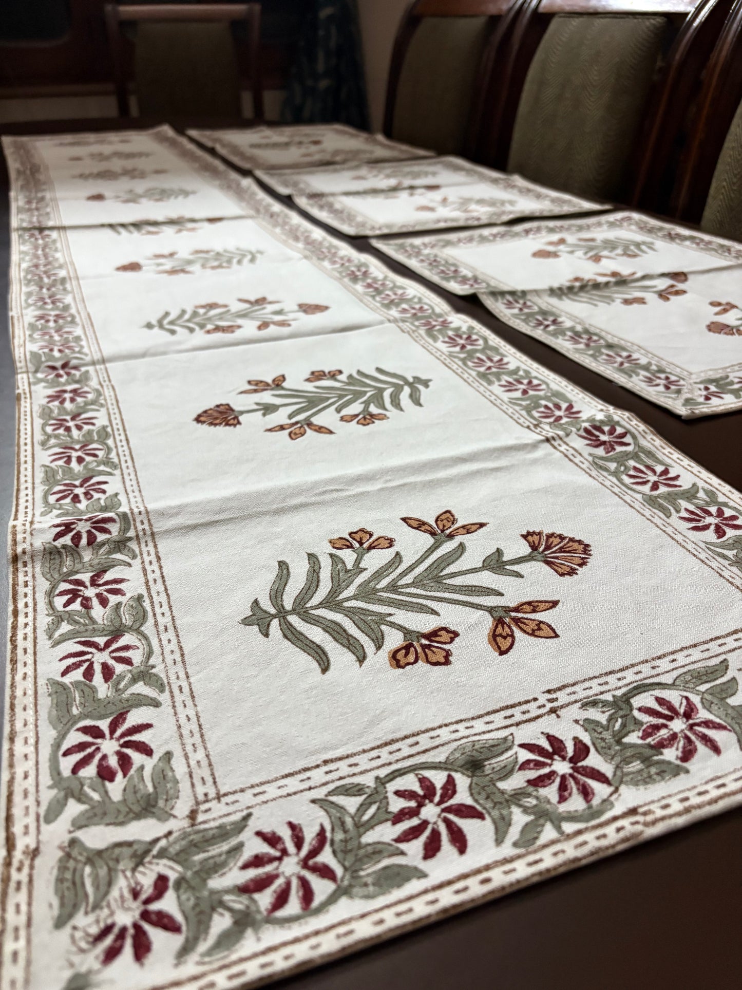 Decorative tablecloth with floral patterns on a wooden table.