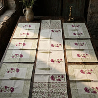 Set of hand block printed table runners and 6 placemats on a wooden table.