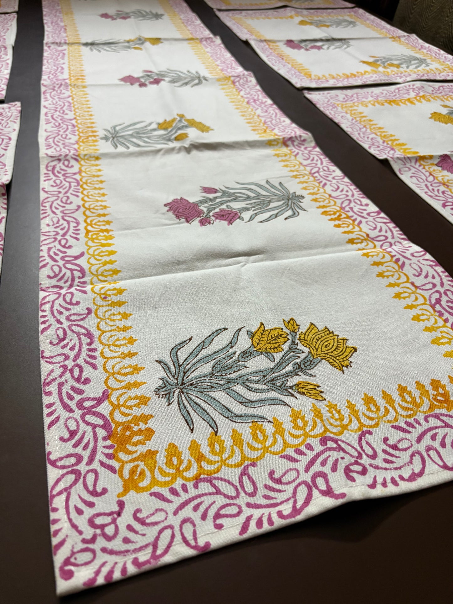 Decorative tablecloth with floral patterns on a dark surface. Table linens cheapest prices highest quality made in india. Authentic hand block printed