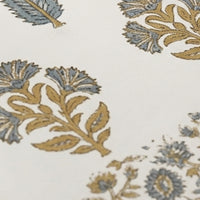 Close-up of a floral block printed patterned fabric with blue and gold colors on a white background.