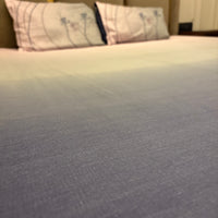 A close-up of a neatly made bed with the Percale Ombre 250 TC Bedsheet + Pillow Cover Pair Set (108x108 - King Size) in Navy Blue Ombre, featuring gradient tones and crafted from 100% long-staple cotton.